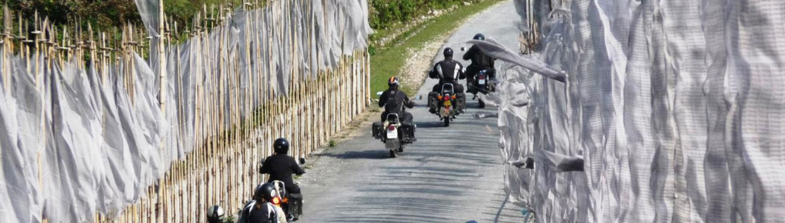 Bikers crossing prayer flags in Bhutan